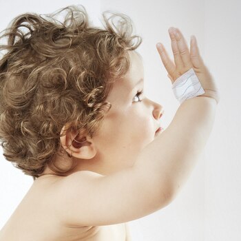 Primer plano de vendaje con Hypafix skin sensitive de Leukoplast en el dorso de la mano de un niño.