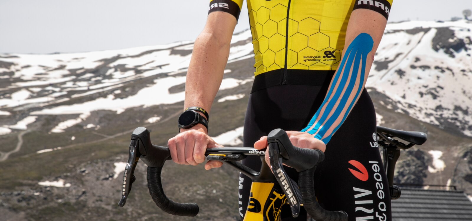 Ciclista utilizando la cinta kinesiológica Leukotape K de Actimove Sports Edition por un desgarro muscular.