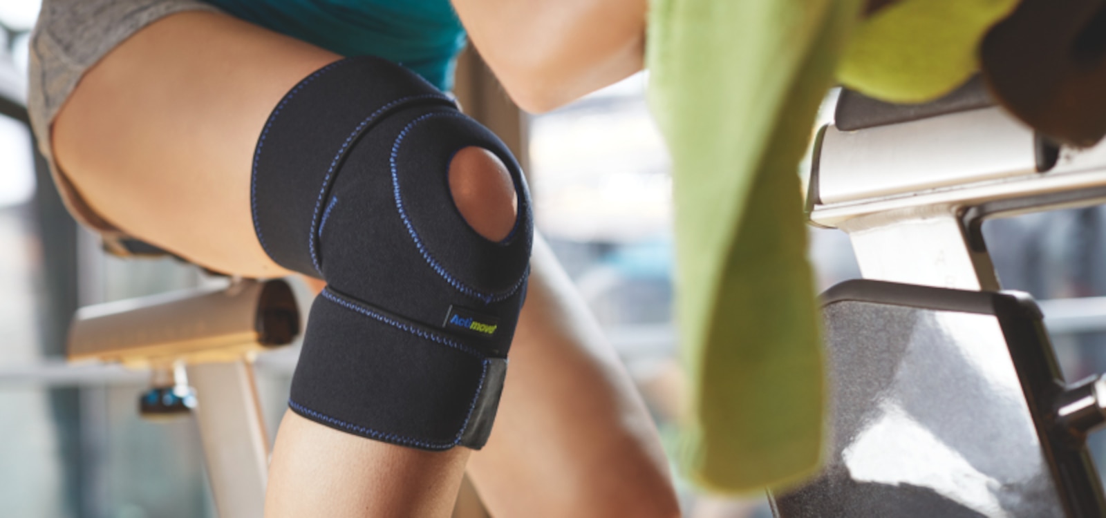 Osoba w stroju sportowym używająca ortezy stawu kolanowego w celu wsparcia rzepki podczas aktywności fizycznej.