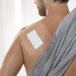 Primer plano de vendaje con Fixomull transparent en espalda después de la ducha.