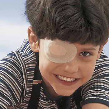 Garçon avec un pansement occlusif de Leukoplast pour les yeux