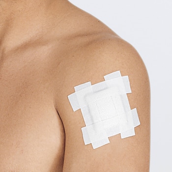 Verbandmiddel op de arm vastzetten met Leukoplast hospital hechtpleister