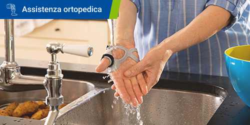 Persona che si lava le mani mentre indossa la stecca per il pollice Rhizo Forte. Il testo "Cura ortopedica" appare in un riquadro.