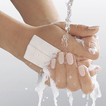 Hænder vaskes med Leukoplast waterproof-tape