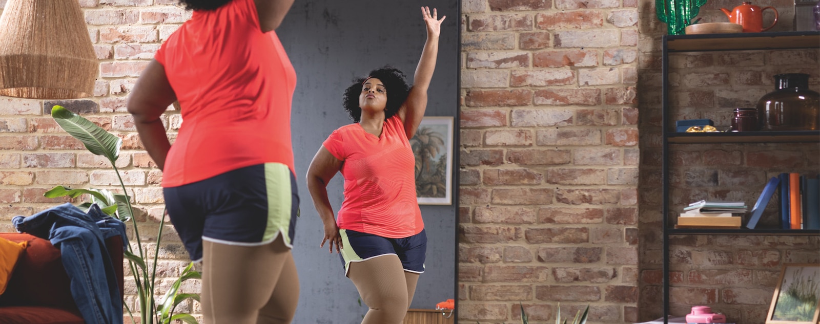 A person wearing compression stockings works out in front of a mirror.