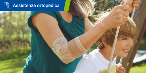 Una donna spinge un bambino su un'altalena mentre indossa la gomitiera Actimove Everyday Supports perché soffre di epicondilite. Il testo "Assistenza ortopedica" è scritto in un riquadro.