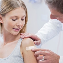 Application of Leukoplast soft white strip on woman’s arm