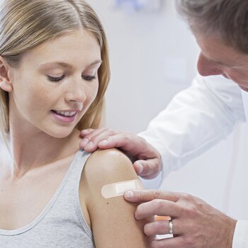 Påføring af Leukoplast soft white-plaster på kvindes arm