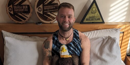 Jame Gane sat on his bed surrounded by his medals and awards