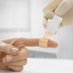 Nærbilde av Leukoplast Universal påføring av plaster på finger