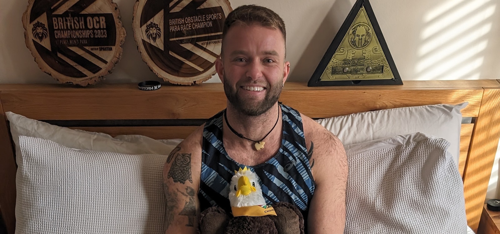 Jame Gane sat on his bed surrounded by his medals and awards