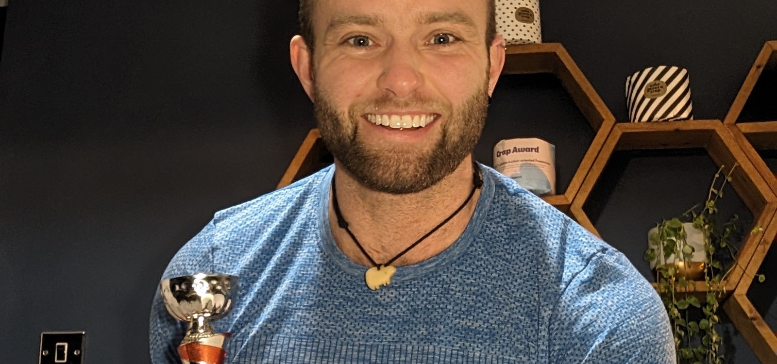 Jamie Gane smiling and holding a trophy in his hands