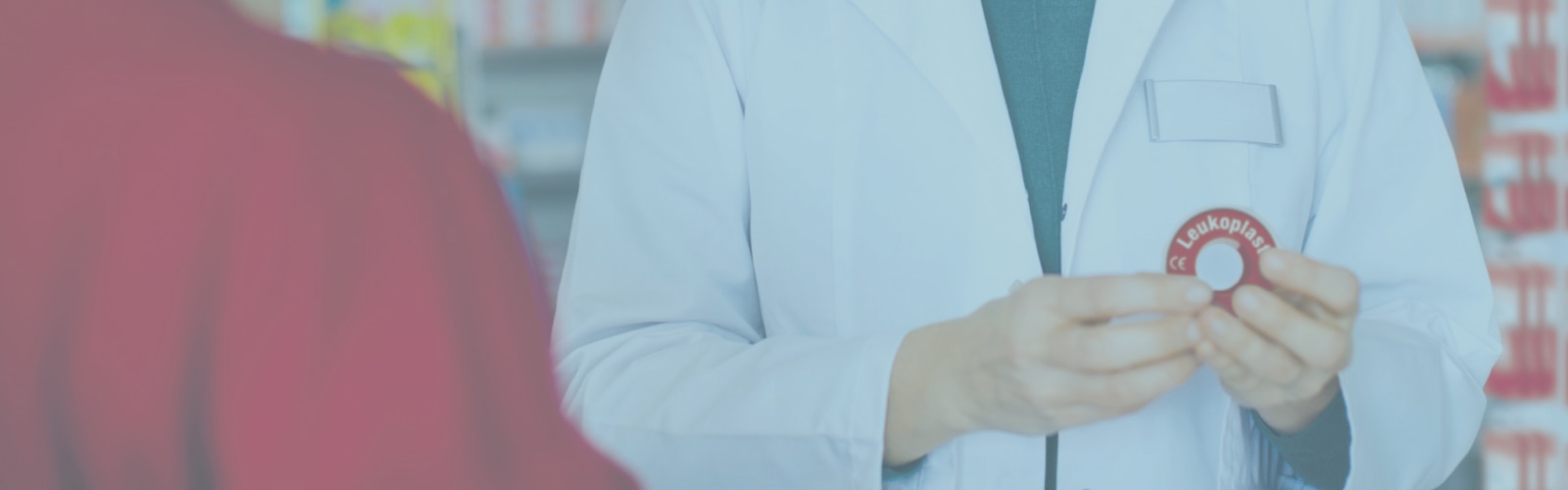 Farmacista che mostra un nastro adesivo Leukoplast.