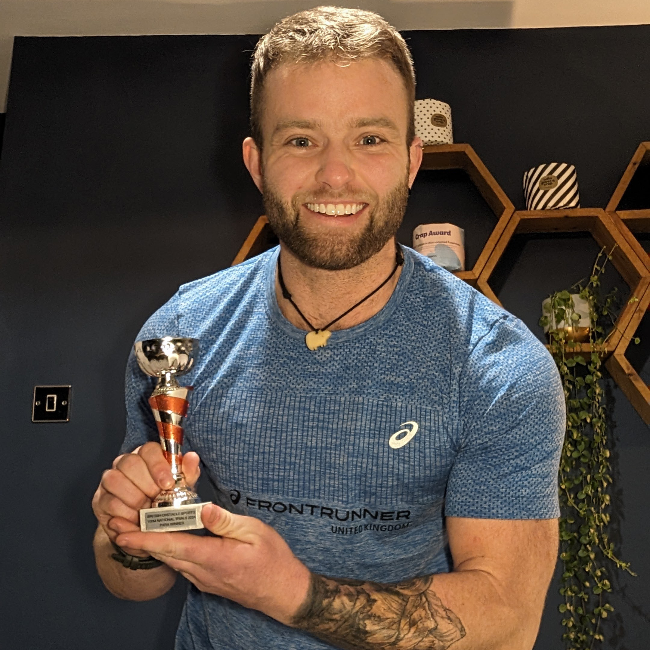 Jamie Gane smiling and holding a trophy in his hands