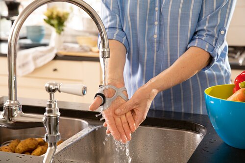 Close up of woman wearing Actimove Professional Line Rhizo Forte Thumb Orthosis, washing her hands

