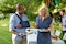 Man interacting with hostess at garden party, wearing an Actimove Professional Line Umerus Comfort Shoulder Immobilizer