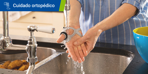 Persona lavándose las manos mientras lleva puesta la férula para el dedo pulgar Rhizo Forte. Se lee el texto “Cuidado ortopédico” en un recuadro.