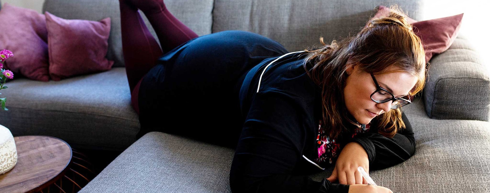 A woman lying on a coach wearing compression garments. 