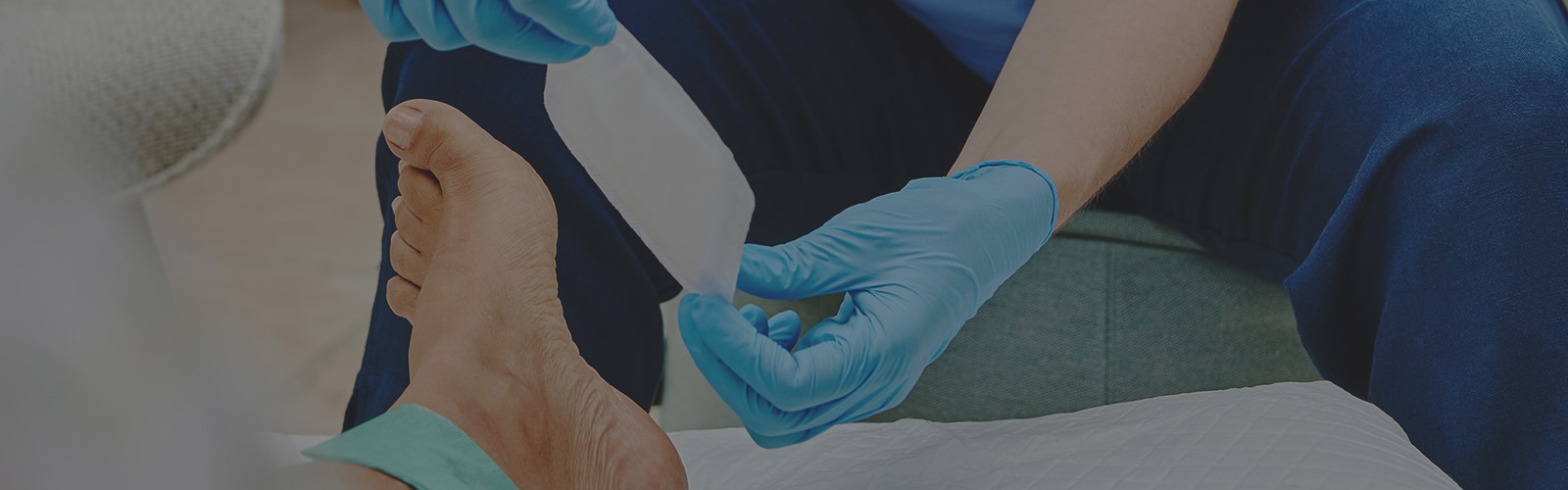 Profesional sanitario aplicando un apósito Cutimed Sorbact en la herida de un paciente.
