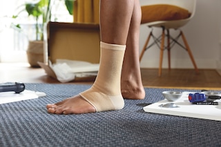 Close-up of man wearing a beige Actimove Arthritis Care Ankle Support