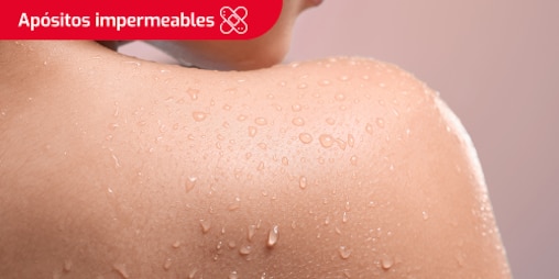 Mujer con la espalda mojada después de nadar. Se lee el texto “Apósitos impermeables” en un recuadro.