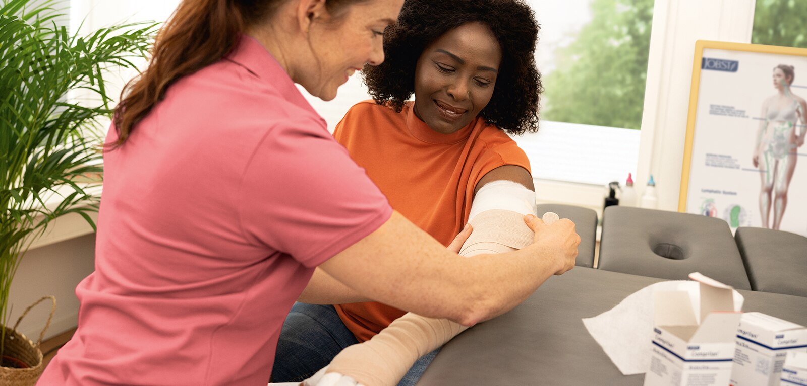 A healthcare professional applying a compression bandage to a woman's arm.