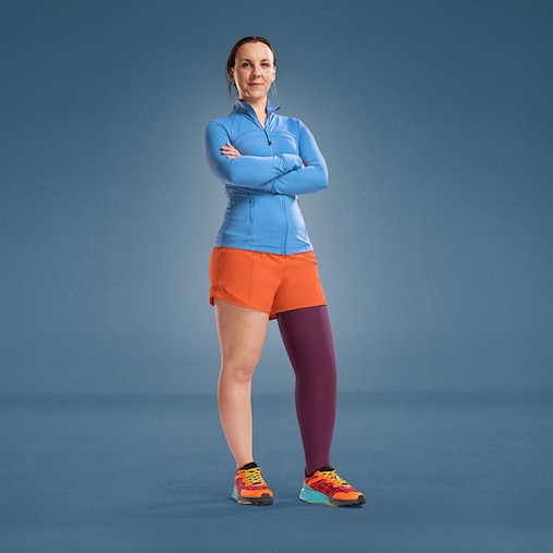 JOBST ambassador Angharad is standing on a blue background, dressed in athletic wear, with a purple compression garment on her leg.