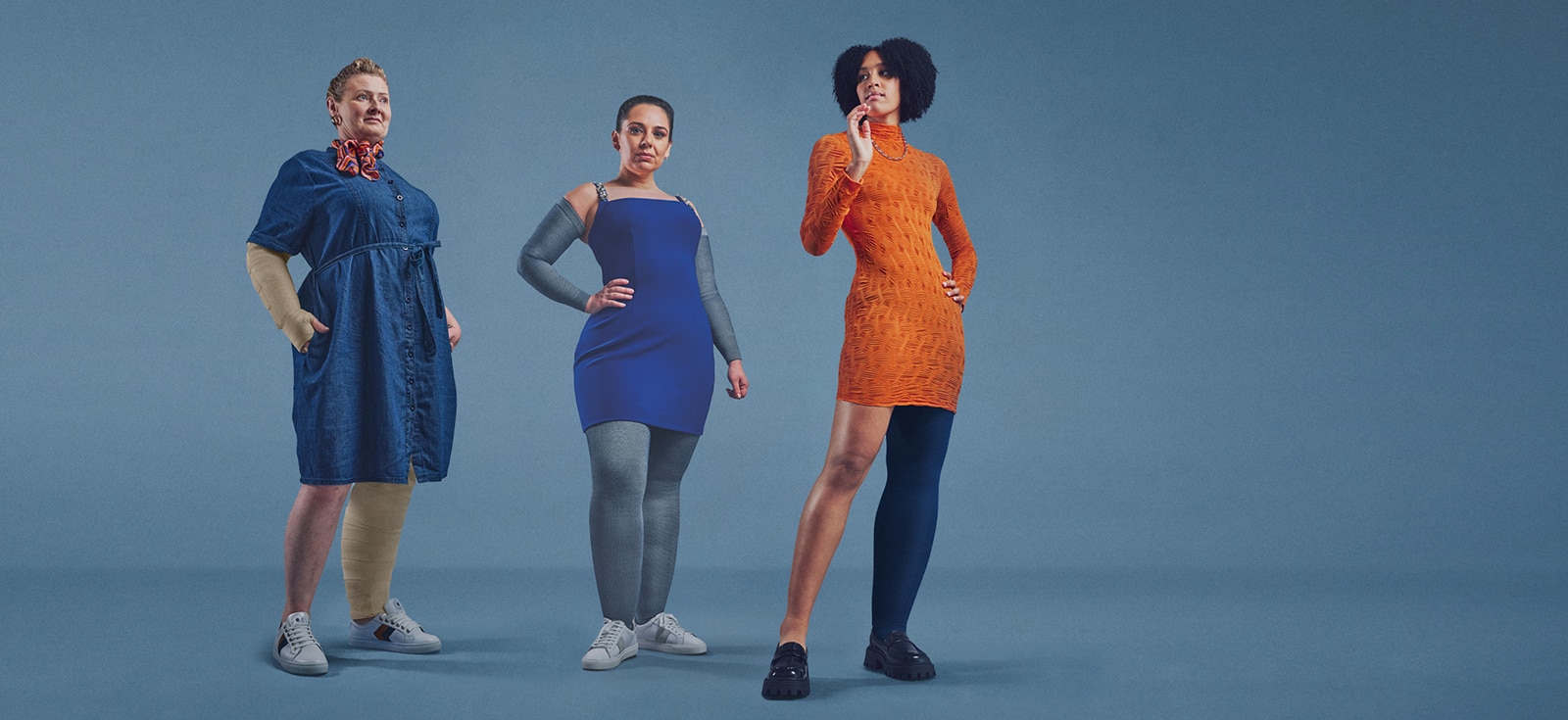 Three women wearing compression garments stand confidently against a blue background.