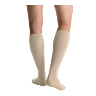 Close-up rear view of a person wearing a pair of JOBST Travel compression socks in beige.