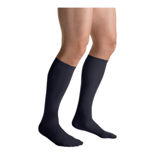 Close-up side view of a person wearing a pair of JOBST Travel compression socks in black.