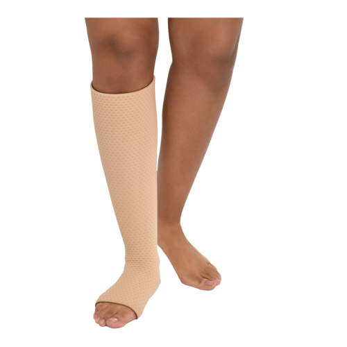 Close-up front view of a person wearing beige-colored JOBST Relax open-toe, knee-high compression sock on one leg.