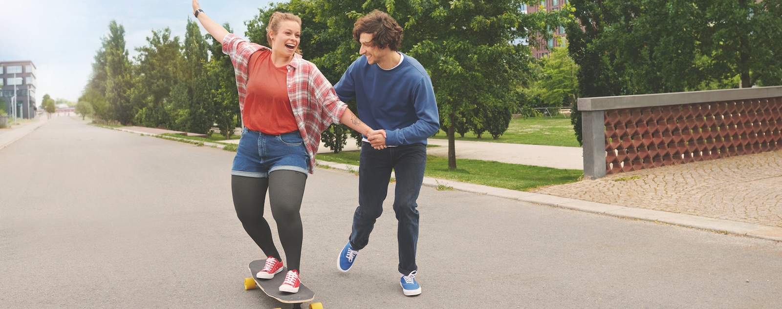 Two women riding on a skateboard.