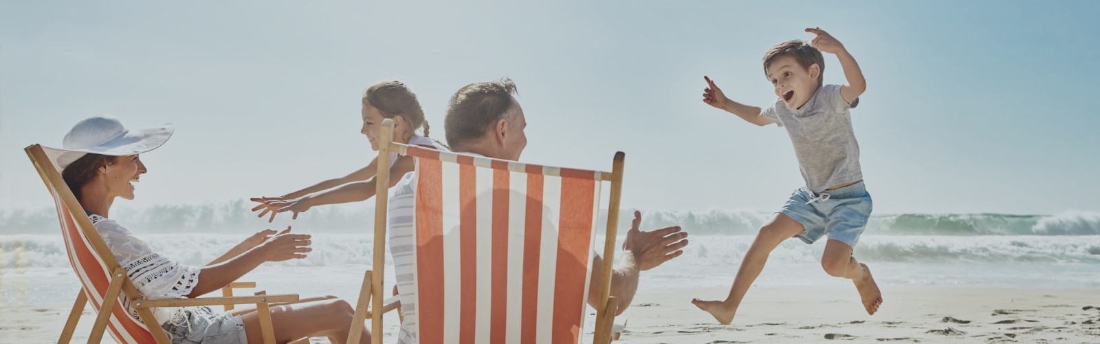Familia disfrutando en la playa durante el verano, jugando y riendo juntos, sin interrupciones gracias a una protección eficaz.