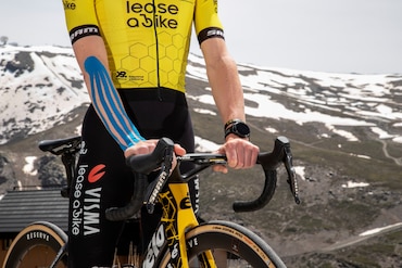 En pige hviler sig mod en væg, mens hun har en knæstøtte på En pige hviler sig mod en væg, mens hun har en knæstøtte på