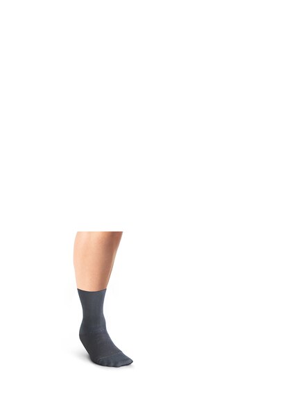 Close up of a person's leg wearing a dark grey JOBST Confidence compression sock. 