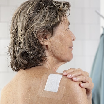 Leukomed T plus skin sensitive dressing by Leukoplast on elderly woman’s back after shower