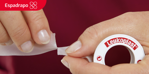 Miniatura de uma pessoa a cortar a fita adesiva para uma ferida