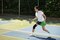 Woman playing pickleball outdoors, wearing an Actimove Sports Edition Knee Support with Closed Patella