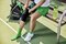 Woman preparing for pickleball practice, putting on an Actimove Sports Edition Knee Support with Closed Patella