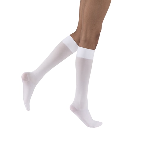 A pair of legs, each wearing a white JOBST UlcerCARE Liner that reaches just below the knee. One leg is behind the other.