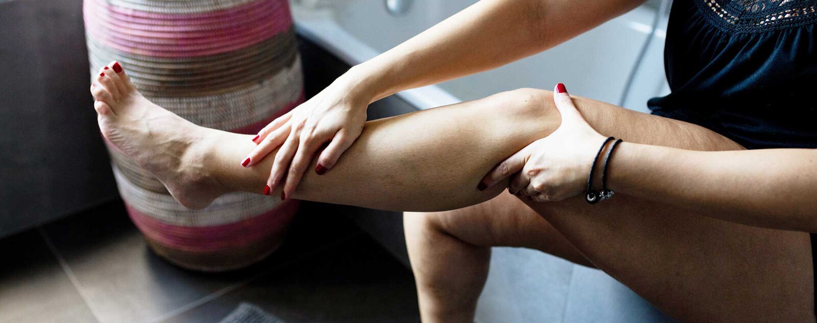 Person massaging their lower leg while seated.