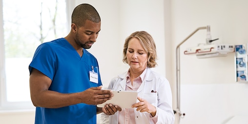 Bilde som viser to sykepleiere som utveksler medisinsk informasjon.