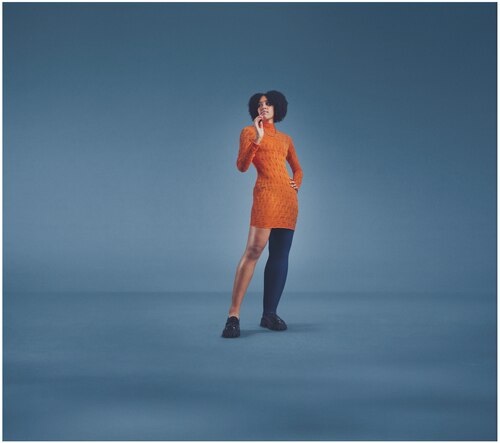 Female in an orange dress wearing the JOBST Elvarex Soft dark blue compression garment for lymphoedema.