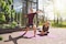 Smiling man wearing Actimove Arthritis Care Knee Support, practicing yoga outdoors with partner
