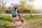 Woman outdoors playing with her dog, wearing the Actimove Everyday Supports Knee Support with Closed Patella with 2 Stays
