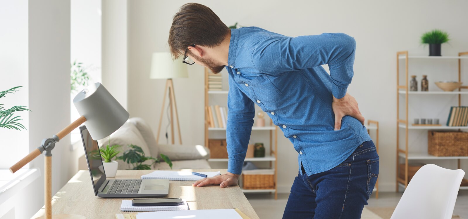 Uomo non cura l’ergonomia sul lavoro e presenta difficoltà posturali che gli provocano lombalgia.