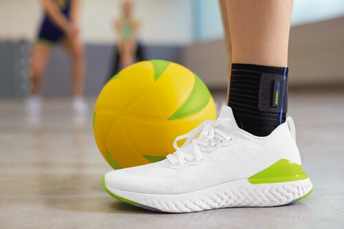 Close up of woman playing volleyball, wearing Actimove Sports Edition Ankle Support Elastic Wrap Around
