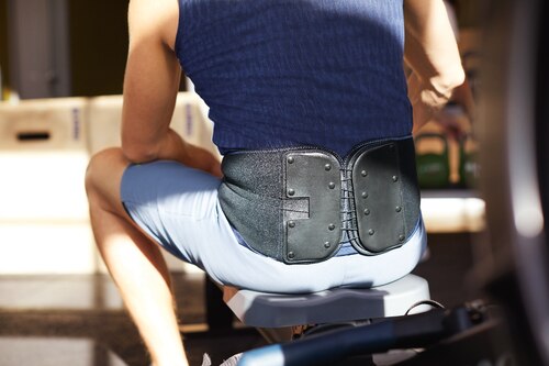 Close up of man at gym wearing an Actimove Sports Edition Back Stabilizer with Pressure Pads
