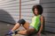 Woman resting outdoors after workout wearing Actimove Sports Edition Knee Support Open Patella in black

