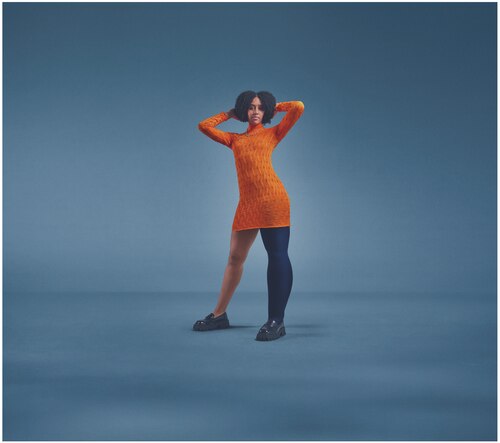 Female in an orange dress wearing the JOBST Elvarex Soft dark blue compression garment for lipoedema.